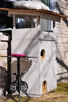 a bird house with a pink cushion on top