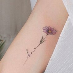 a woman's arm with a flower on it and the word love written in cursive writing