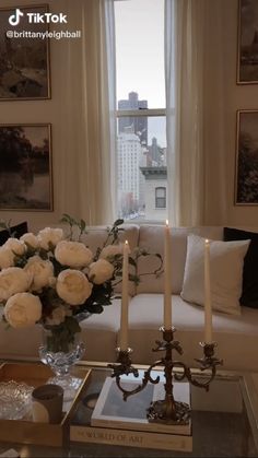 a living room filled with white flowers and candles