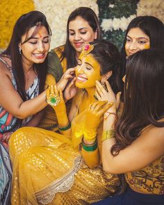 three women are getting their faces painted yellow