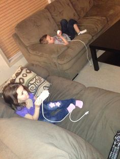 two children laying on couches playing video games