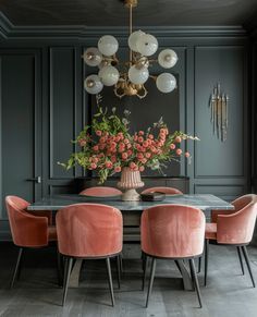 a dining room table with pink chairs and a chandelier