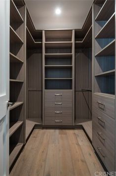 an empty walk in closet with wooden floors