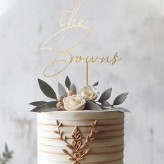 a wedding cake decorated with flowers and the words the browns written on top is white frosting