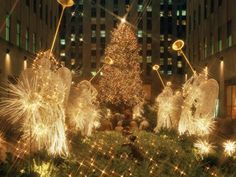 a christmas tree surrounded by angel statues and lights