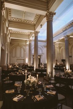 an elegant dining room with columns and tables