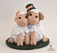 two sheep figurines sitting next to each other