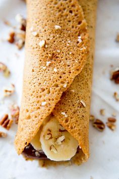 a banana and nut crepe on a white plate