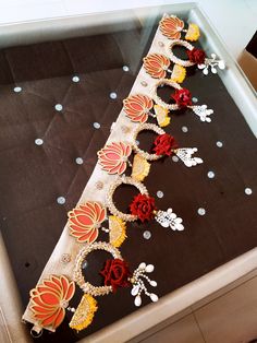 a table topped with lots of different colored flowers on top of a black cloth covered tray