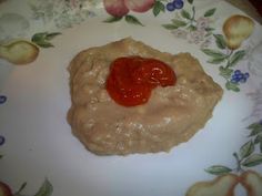 a white plate topped with food on top of a floral design table cloth covered in sauce