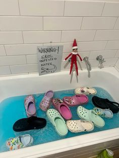 the elf is sitting in the bathtub with many pairs of slippers on it