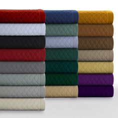 a stack of folded sheets and blankets in different colors on a white background with the same color