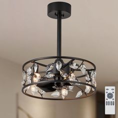 a chandelier hanging from a ceiling with remote controls