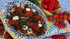 a plate of food on a table with tomatoes and peppers