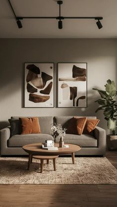 a living room with two paintings on the wall and a coffee table in front of it