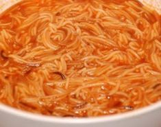 a white bowl filled with noodles on top of a table