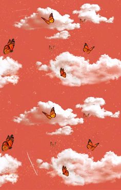 many butterflies flying in the sky above some white clouds with pinkish hues on them