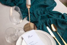 a table setting with place settings and wine glasses