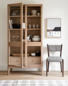 a wooden bookcase sitting next to a chair in a living room