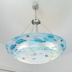 a chandelier hanging from the ceiling with blue and white glass designs on it