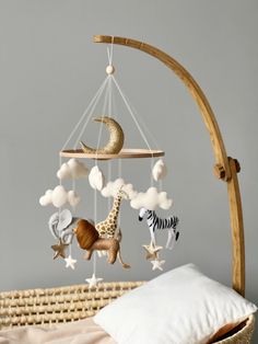 a baby crib mobile with animals and stars hanging from it