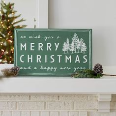 a green christmas sign sitting on top of a mantle