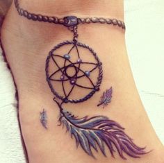 a small tattoo on the side of a woman's stomach with an arrow and dream catcher