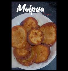 some food is on a white plate with the words malpua written in it