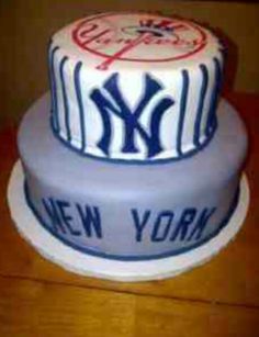 a new york yankees cake on a wooden table with white frosting and blue lettering