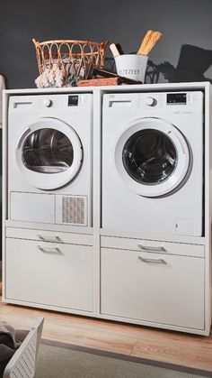 a washer and dryer sitting next to each other in front of a basket