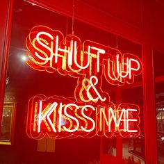 a red neon sign that says shut up and kiss me