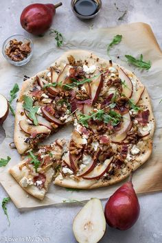 an apple and goat cheese pizza on a cutting board next to some sliced pears