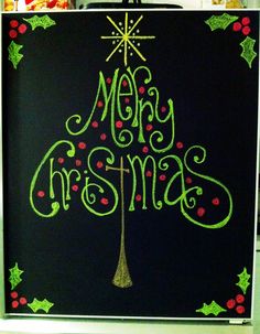 a chalk board with the words merry christmas written on it and a lit up tree