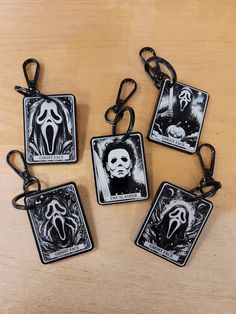 four halloween tags with scary faces on them sitting on a wooden table next to each other