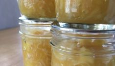 jars filled with yellow liquid sitting on top of a wooden table