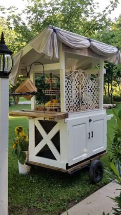 a small white cart sitting on top of a lush green field