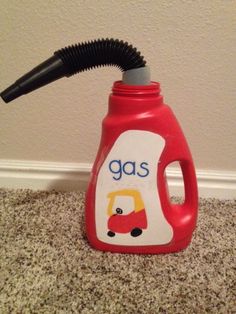 a red gas bottle with a black hose sticking out of it's top on the floor