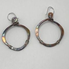 "These bronze earrings are hammered and given a patina finish for a rustic look. Mixed metal of bronze and sterling silver have a nice two tone effect. These earrings are very rustic and earthy and make a unique statement. They measure 1 3/4\" Long. Approximate measurements without an ear wire attached: 1 1/8\" widest part x 1 5/16\"high -(29mm widest part x 33mm High). These are also available in a larger version-see link below. The patina effect gives these earthy earrings lots of color. Every Handmade Metal Earrings For Everyday Use, Handmade Drop Wrap Earrings For Everyday, Handmade Everyday Circular Earrings, Handmade Everyday Circle Earrings, Everyday Handmade Circular Earrings, Hand Forged Copper Dangle Hoop Earrings, Hand Forged Copper Hoop Earrings With Dangle, Handmade Metal Wrap Earrings, Handmade Metal Wrap Earrings For Everyday