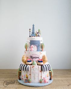 a three tiered cake is decorated with an image of peppuccini's castle