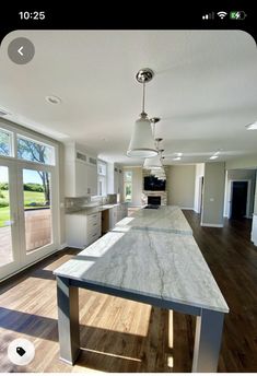 a large kitchen with an island in the middle and lots of windows on both sides