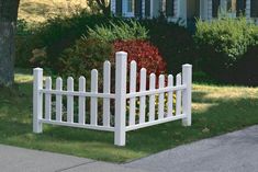 a white picket fence sitting on the side of a road