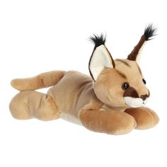 a stuffed animal is laying down on the ground with it's tail curled up