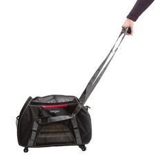 a person pulling a black rolling bag with wheels on it's side and holding the handle