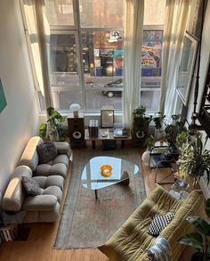 an overhead view of a living room with couches, coffee table and plants in the corner