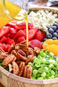 a wooden bowl filled with fruit and nuts