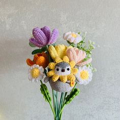 a crocheted flower arrangement in a vase with an owl and flowers on it