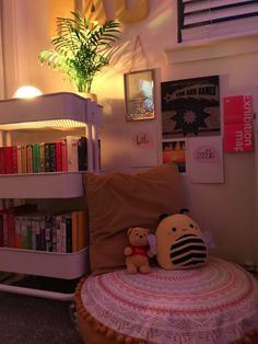 a teddy bear sitting on top of a bed next to a book shelf