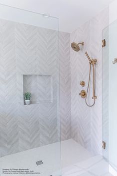 a bathroom with white and gold fixtures in the shower