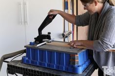 a woman is working on an object in a room