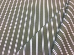 a close up view of a green and white striped shirting material with vertical stripes